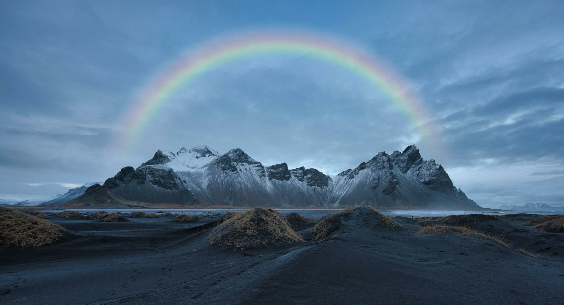 Rainbow over snow capped mountains